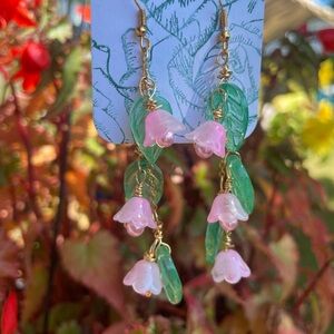 Lilly of the Valley dangles with pink petals and green leaves